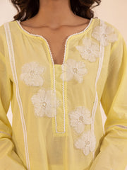 Yellow top with white floral embroidery on a plain background